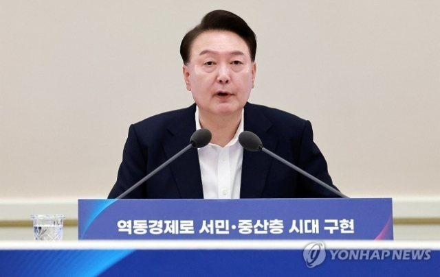 윤석열 대통령이 3일 서울 종로구 청와대 영빈관에서 열린 '하반기 경제정책방향 및 역동경제 로드맵 발표' 회의에서 F1 경주의 피트 스톱 사진을 들고 마무리 발언을 하고 있다. 연합뉴스