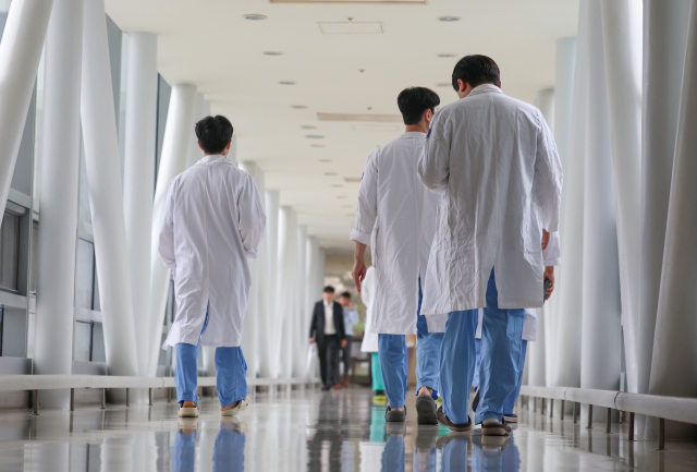 정부가 수련병원 이탈 5개월이 다 되도록 현장에 복귀하지 않은 전공의에 대해서도 면허정지 등 행정 처분을 하지 않겠다는 방침을 8일 공식 확정했다. 서울의 한 대형병원에서 이동하는 의료진. 연합뉴스