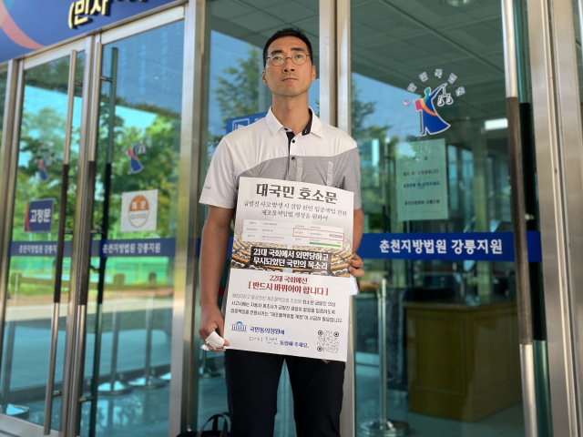 지난달 도현 군의 아버지 이상훈 씨가 춘천지방법원 강릉지원 앞에서 ‘도현이법’(제조물 책임법 일부법률개정안) 제정을 위한 국민동의 청원 참여를 촉구하는 모습. 연합뉴스