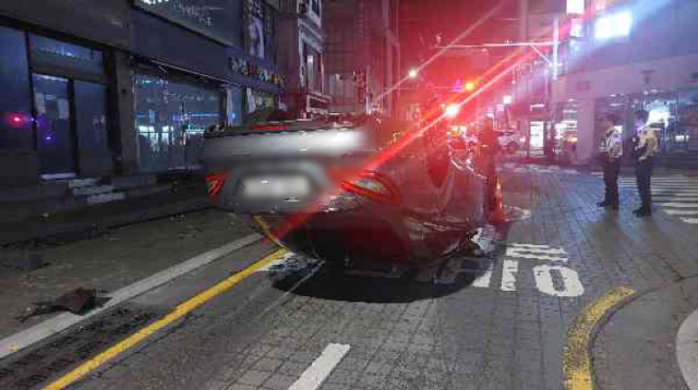13일 오전 1시께 부산 해운대구 우동에서 승용차가 가로등을 들이받고 한 바퀴 돈 뒤 완전히 뒤집혀 있다. 부산경찰청 제공