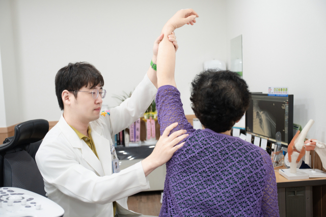 오십견과 회전근개 파열은 비슷한 듯하지만 전혀 다른 질환이다. 증상은 비슷해도 원인과 치료법이 다르다. 춘해병원 정형외과 김종민 과장이 환자의 팔을 들어 올려 보고 있다. 춘해병원 제공