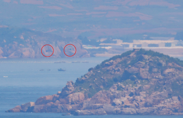 북한이 오물풍선 살포 및 동해상으로 탄도미사일을 발사한 지난단 26일 오전 인천시 옹진군 대연평도에서 바라본 북한 황해도 해안에 설치된 해안포 포문이 열려 있다. 연합뉴스