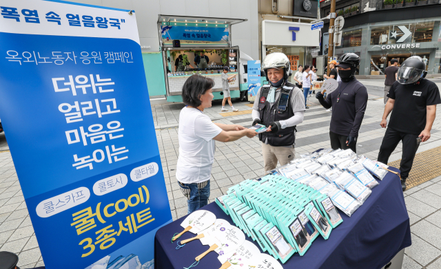 22일 오후 부산진구 서면 ABC 마트 앞 하트 조형물 인근에서 부산노동권익센터가 부산근로자건강센터, 부산진구자원봉사센터와 함께 여름철 더위와 싸우는 옥외노동자를 응원하는 캠페인 ‘폭염 속 얼음왕국’을 진행해 옥외노동자들에게 쿨 3종세트(쿨토시, 쿨스카프, 쿨타월)을 나눠주고 있다. 김종진 기자 kjj1761@