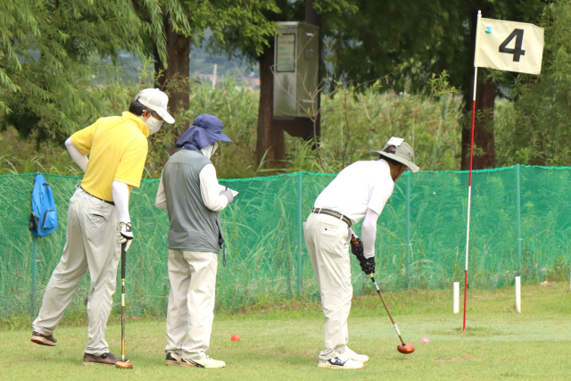 지난 22일 2024 부산시장배 슈퍼컵 파크골프대회 4차 예선에서 한 선수가 퍼팅을 시도하는 사이 다른 선수는 심판이 기록하는 스코어카드를 살피고 있다. 남태우 기자
