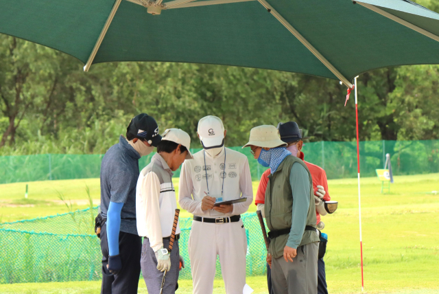 지난 22일 2024 부산시장배 슈퍼컵 파크골프대회 4차 예선에 참가한 선수들이 뜨거운 햇빛을 피해 차양막 아래에서 심판의 스코어 기록을 확인하고 있다. 남태우 기자