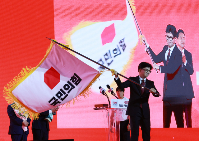 국민의힘 한동훈 당 대표 당선자가 23일 오후 경기도 고양시 킨텍스에서 열린 국민의힘 제4차 전당대회에서 당기를 흔들고 있다. 연합뉴스