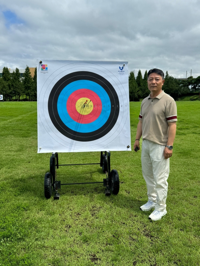부산 사상구청 양궁팀 신성근 감독이 최근 선수들과 양궁 훈련을 마친 뒤 과녁 앞에서 포즈를 취하고 있다. 신성근 감독 제공
