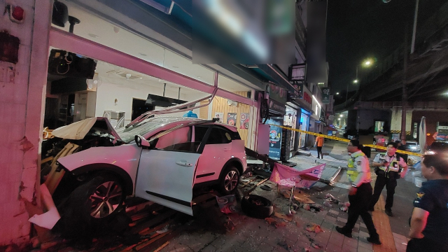 28일 오전 1시 25분께 부산 남구 문현동 한 거리에서 전기택시가 상가로 돌진했다. 이 사고로 60대 택시 운전자 A 씨가 부상을 입었다. 사진은 상가 건물에 박힌 전기 택시 모습. 부산 남부경찰서 제공