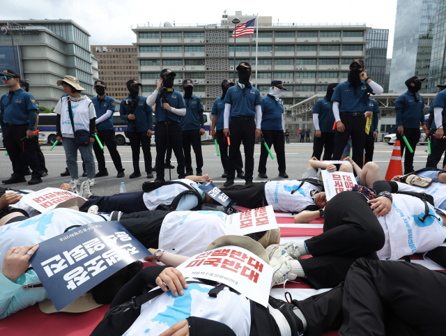 서울자주통일평화연대 회원들이 28일 오전 서울 종로구 주한미국대사관 건너편에서 9.19 군사 합의 전면 중단한 것을 규탄하고 대북전단 사용 중단 등을 촉구하며 바닥에 누워 퍼포먼스를 하고 있다. 연합뉴스