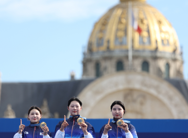 28일(현지시간) 프랑스 파리 레쟁발리드에서 열린 2024 파리올림픽 양궁 여자단체전에서 우승한 한국 전훈영, 임시현, 남수현 선수(왼쪽부터)가 시상대에서 손가락과 메달로 10연패 세리머니를 하고 있다. 연합뉴스