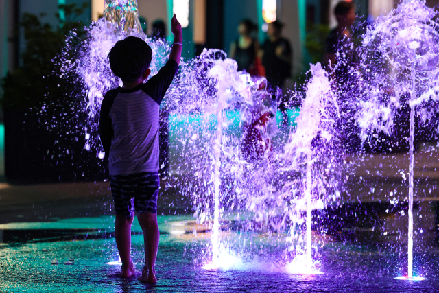 서울 전역에 폭염주의보가 내리며 더운 날씨를 보인 24일 저녁 한 어린이가 서울 종로구 광화문광장에서 물놀이를 즐기고 있다. 연합뉴스