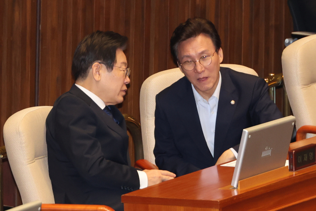 더불어민주당 차기 지도부 경선에 나선 이재명 전 대표와 김민석 의원이 30일 오전 국회 본회의에서 ‘방송 4법’ 가운데 네 번째 법안인 교육방송공사법(EBS법) 개정안에 대한 표결을 앞두고 대화하고 있다. 연합뉴스