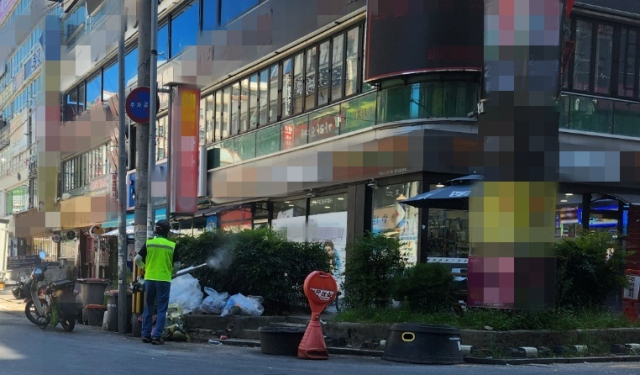 30일 오전 경남 창원시 성산구 상남상업지구에 쌓인 쓰레기에서 악취 관련 민원이 접수돼 현장에서 방역 작업 중인 모습. 강대한 기자