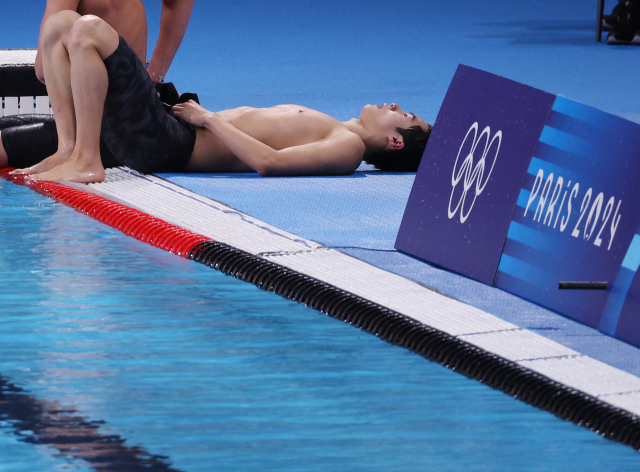30일(현지시간) 프랑스 파리 라데팡스 아레나에서 열린 2024 파리올림픽 수영 남자 계영 800m 결승에서 마지막 영자로 나선 황선우가 경기를 마친 뒤 풀장 옆에 누워있다. 양재훈, 이호준, 김우민, 황선우가 출전한 대표팀은 7분07초26을 기록해 6위를 기록했다. 연합뉴스