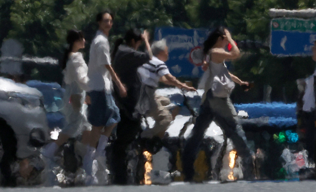 전국 대부분 지역에 폭염 특보가 발효된 31일 오후 대구 중구 공평네거리에서 시민들이 열기로 가득한 도로 위를 걸어가고 있다. 연합뉴스
