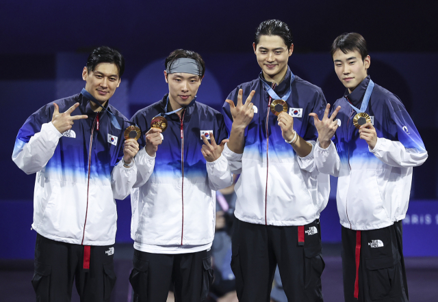 남자 사브르 대표팀이 31일(현지시간) 프랑스 파리 그랑 팔레에서 열린 2024 파리올림픽 펜싱 사브르 남자 단체 헝가리와 결승에서 승리해 올림픽 3연패를 달성한 뒤 금메달을 수여받고 기념 촬영을 하고 있다. 연합뉴스