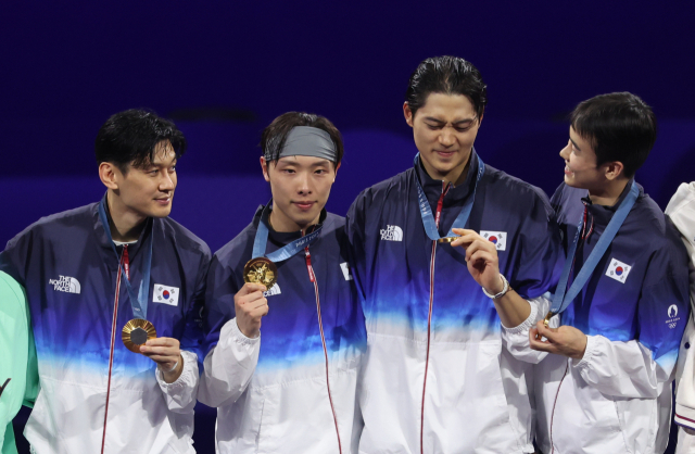 31일(현지시간) 프랑스 파리 그랑 팔레에서 열린 2024 파리올림픽 펜싱 남자 사브르 단체 결승 시상식에서 한국 구본길, 오상욱, 도경동, 박상원이 금메달을 목에 걸고 있다. 연합뉴스