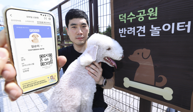 농림축산식품부는 5일부터 오는 9월 30일까지 '반려견 등록 자진신고 기간'을 운영한다고 4일 밝혔다. 사진은 모델이 반려견 놀이터에서 PASS 반려동물 모바일 확인서비스를 이용하는 모습. KT 제공