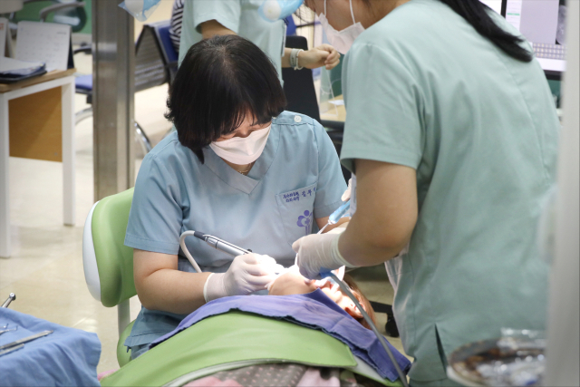 부산의료원 장애인치과센터 김부경 센터장이 행동 조절이 어려운 장애인 환자를 수면마취로 안정을 시킨 뒤 치과 진료를 하고 있다. 부산의료원 제공
