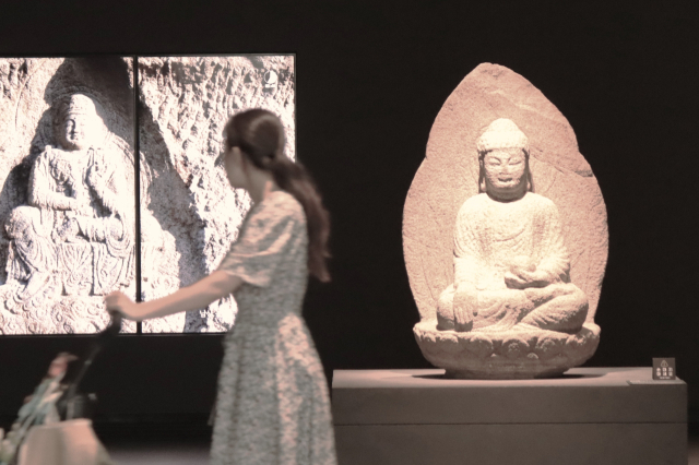 한 여성이 유모차를 밀면서 경북 경주시 국립경주박물관 신라미술관 불교 조각상 앞을 지나가고 있다. 남태우 기자