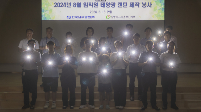 한국남부발전 임직원들이 지난 13일 본사 강당에서 방학을 맞은 자녀들과 함께 에너지 빈곤국가에 기증할 태양광 랜턴을 제작한 후 기념촬영을 하고 있다. 남부발전 제공