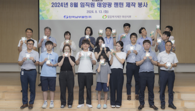 한국남부발전 임직원들이 지난 13일 본사 강당에서 방학을 맞은 자녀들과 함께 에너지 빈곤국가에 기증할 태양광 랜턴을 제작 후 기념촬영을 하고 있다. 남부발전 제공