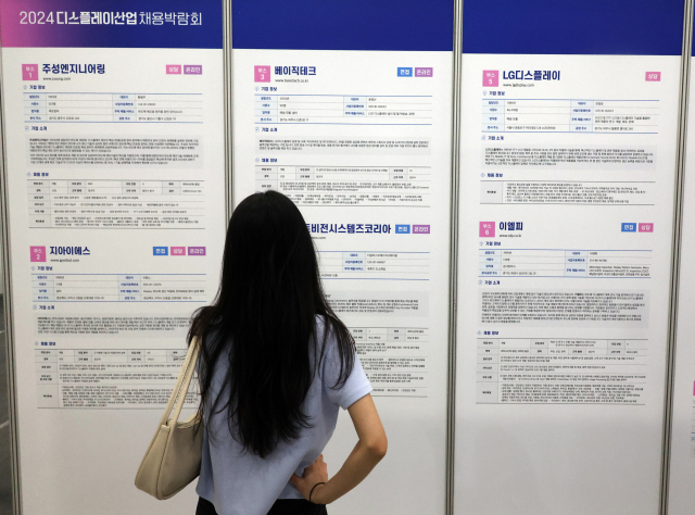 지난 14일 서울 코엑스에서 열린 디스플레이산업채용박람회에서 한 시민이 안내문을 보고 있다. 연합뉴스