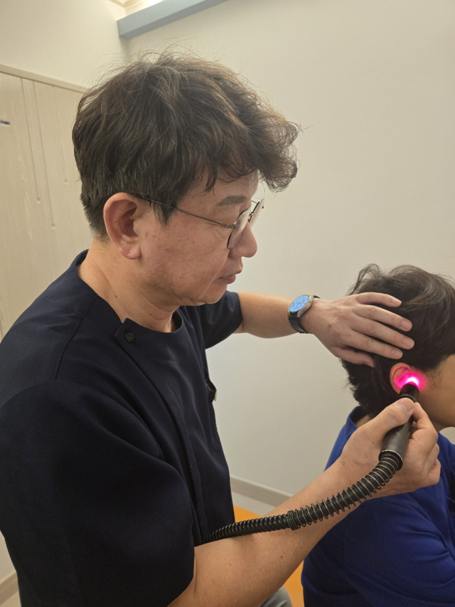 주관한의원 이주관 원장이 인체 주요 경혈에 레이저침 시술을 하고 있다.