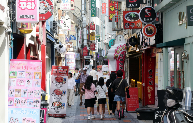 자영업자 소상공인 대상 회생 프로그램인 ‘새출발기금’의 올해 6월까지 신청자 수가 지난해 전체 신청자 수에 육박하고 있는 것으로 나타났다. 20일 오후 부산 중구 광복로 인근 상가들이 밀접한 거리에 시민들이 지나가고 있다. 정종회 기자 jjh@