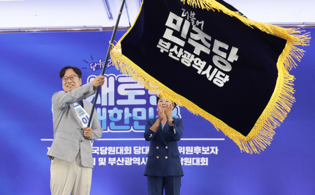 지난달 27일 부산 벡스코에서 열린 더불어민주당 당원대회에서 부산시당위원장에 당선된 이재성 사하을 지역위원장이 부산시당 기를 흔들고 있다. 정대현 기자 jhyun@