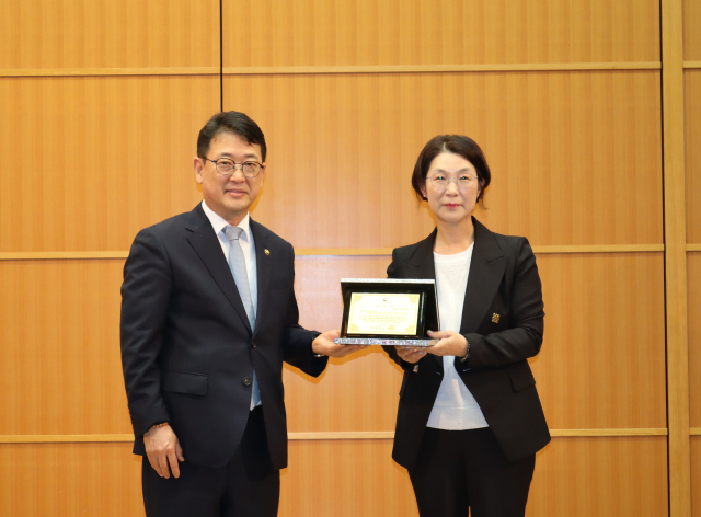 최응천 국가유산청장이 23일 오후 일본 시모노세키 소재 해협멧세 국제회의장에서 개최된 ‘조선통신사 한일 문화교류’ 국제 심포지엄에 앞서 조선통신사선 관련 한·일 교류에 기여한 기여한 이미연(오른쪽) 부산문화재단 대표에게 감사패를 수여한 뒤 기념촬영을 하고 있다. 국가유산청 제공