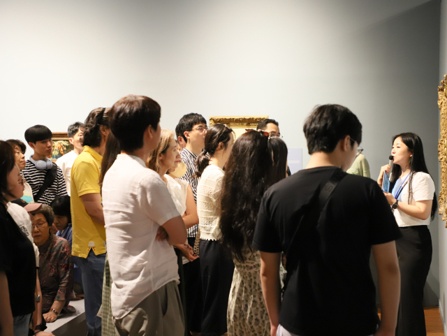 ‘모네에서 앤디워홀까지’전에서 도슨트 설명을 듣고 있는 관람객들 모습. 부산문화회관 제공