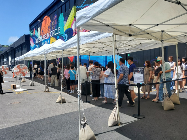 무더위가 기승을 부리는 한낮에도 아르떼뮤지엄 부산을 방문한 관객들이 밖에서 줄을 서서 입장을 기다리고 있다. 아르떼뮤지엄 제공