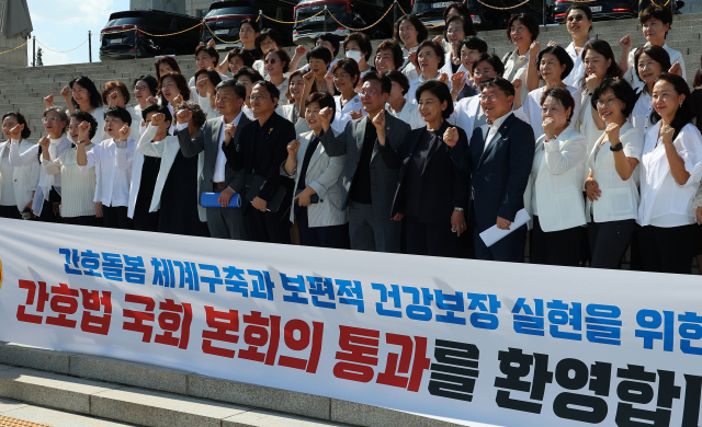 대한간호협회 소속 간호사들이 28일 오후 국회 본회의에서 숙원이었던 간호법이 통과된 뒤 국회의원들과 함께 기념촬영을 하고 있다. 연합뉴스