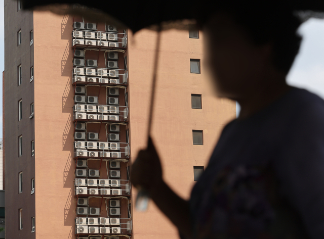 무더위 속에 지난달 13일 오후 서울의 한 건물에 에어컨 실외기들이 작동하는 모습. 연합뉴스