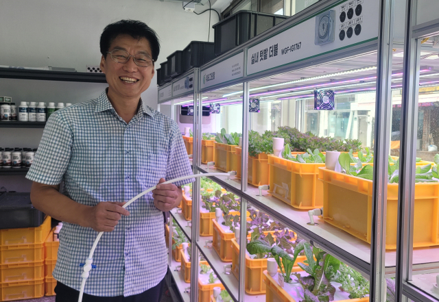 조원술 대표가 부산 수영구 수영동의 워터그린팜 사무실에 설치된 스마트 실내 텃밭을 소개하고 있다.