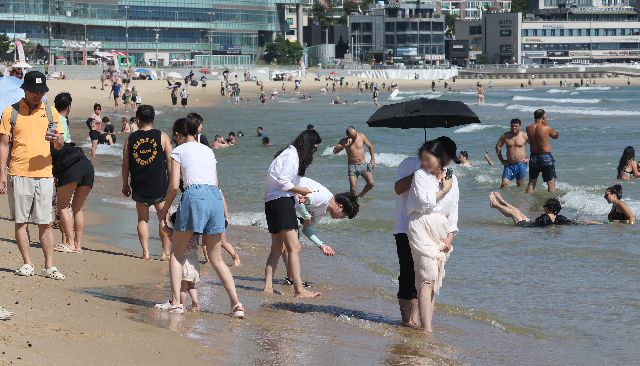 부산 해운대해수욕장에서 외국인 관광객들이 가벼운 물놀이와 바람을 쐬며 더위를 식히고 있다. 정종회 기자 jjh@