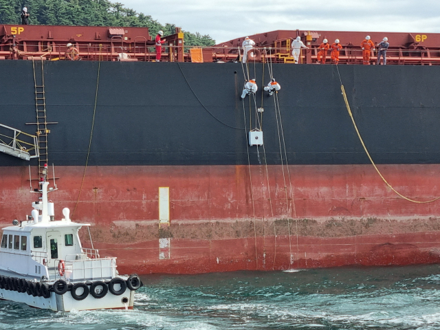 부산해양경찰서는 25일 오후 ‘민관 합동 해상방제 훈련’을 실시했다. 사진은 중앙특수구조단 대원이 기름이 새는 구멍을 막으러 선박 외벽에 매달려 있는 모습. 김준현 기자 joon@