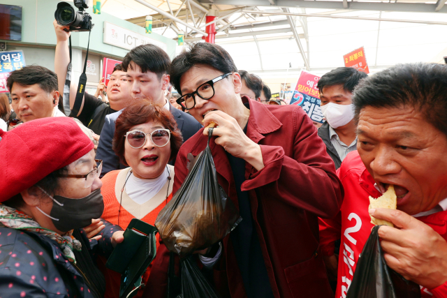 8일 오전 전남 곡성기차마을전통시장에서 국민의힘 한동훈 대표가 직접 구매한 붕어빵을 먹고 있다. 연합뉴스
