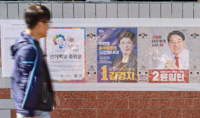 8일 오후 10·16 금정구청장 보궐선거 후보들의 벽보를 한 유권자가 바라보고 있다. 김종진 기자 kjj1761@