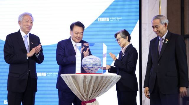 윤석열 대통령이 9일 싱가포르 오차드호텔에서 열린 제47회 싱가포르 렉처에서 참석 패널들로부터 기념 도자기를 선물받고 있다. 연합뉴스