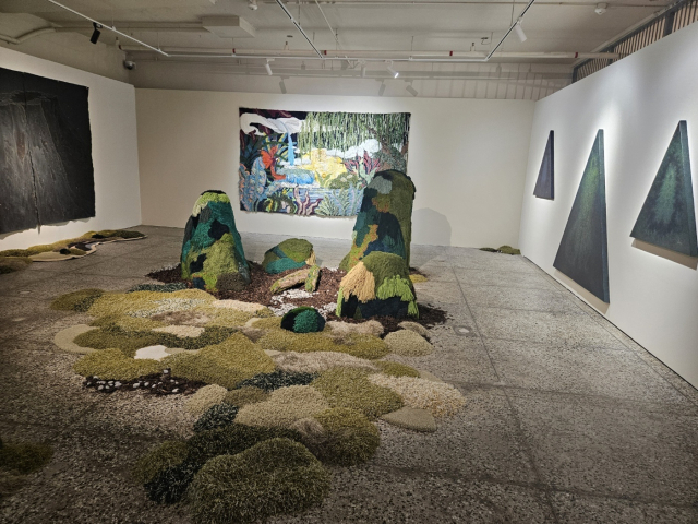 환상 숲 팀의 전시 전경. 타프팅 작업을 하는 담다 작가와 나무판에 그림을 그리는 수라 작가의 회화가 돋보인다. 김효정 기자