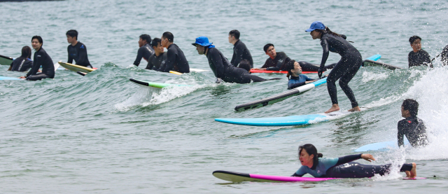 16일 송정의 서핑문화를 알리기 위한 ‘2024 송정서프빌리지 선셋 피크닉’ 뮤직 페스티벌이 개최된다. 송정해수욕장에서 서핑을 즐기는 서퍼들의 모습. 부산일보DB