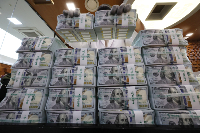 달러 가치가 주요국 통화 대비 10% 넘게 하락하는 동안 원화 가치는 달러 대비 3% 오르는 데 그친 것으로 나타났다. 서울 중구 하나은행 위·변조 대응센터에서 직원이 달러를 정리하고 있는 모습. 연합뉴스