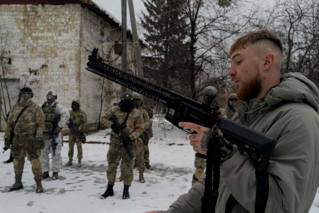 지난 23일 우크라이나 키이우에서 열린 군사훈련 과정에서 군 교관이 현지 민간인을 상대로 무기를 다루는 방법을 시연하고 있다. AFP연합뉴스