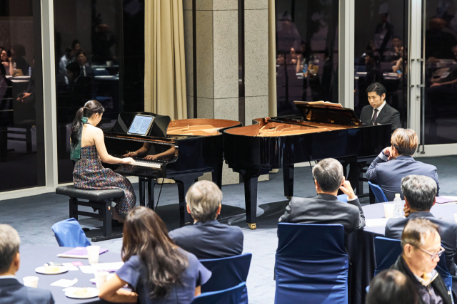 지난 22일 오후 부산 해운대구 누리마루 APEC하우스에서 열린 부산메세나협회 창립 3주년 축하 연주회 모습. 피아니스트 이진상(한국예술종합학교 음악원 교수)과 부산 출신 음악 영재 박해림(한국예술종합학교 음악원 재학)이 듀오로 모차르트 '두 대의 피아노를 위한 소나타 D장조'를 연주하고 있다. 부산메세나협회 제공
