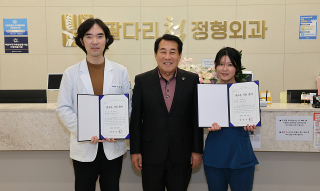 나동연 양산시장이 26일 오후 교통사고 현장에서 발 빠른 응급처치로 부상자의 목숨을 구한 이동현 원장과 조혜인 간호조무사에게 ‘의로운 시민’ 증서를 수여한 뒤 기념사진을 찍고 있다. 양산시 제공