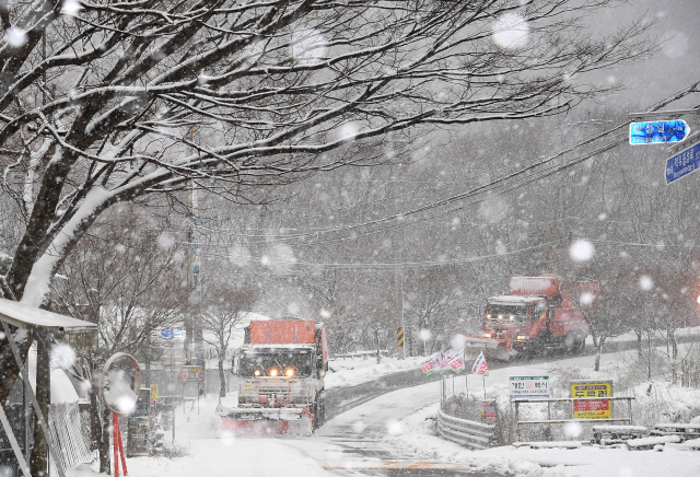 첫눈이 내린 27일 오전 경남 거창군 북상면 황점마을 앞 도로에 많은 눈이 내리자 제설 차량이 쌓인 눈을 치우고 있다. 거창군 제공