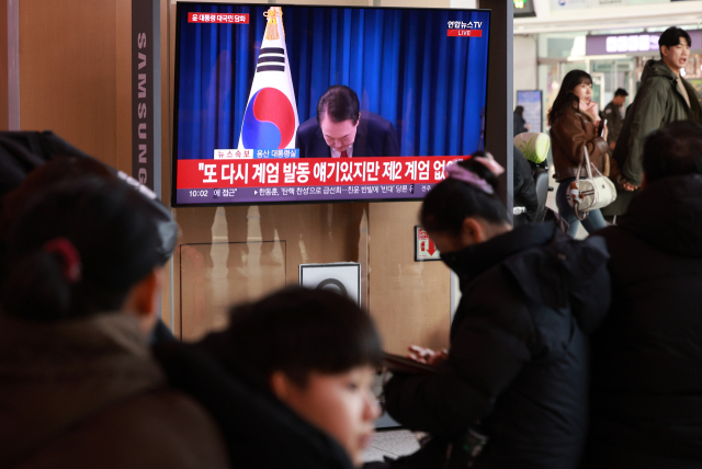 윤석열 대통령 탄핵소추안 표결이 예정된 7일 오전 서울역 대합실에서 시민들이 대통령 대국민 담화 중계를 지켜보고 있다. 연합뉴스