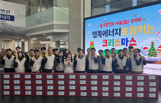 한국동서발전 따숨 꾸러미 '행복에너지로 밝히는 크리스마스 선물꾸러미' 전달식에 참여한 동서발전 임직원들이 단체사진을 촬영하는 모습. 동서발전 제공